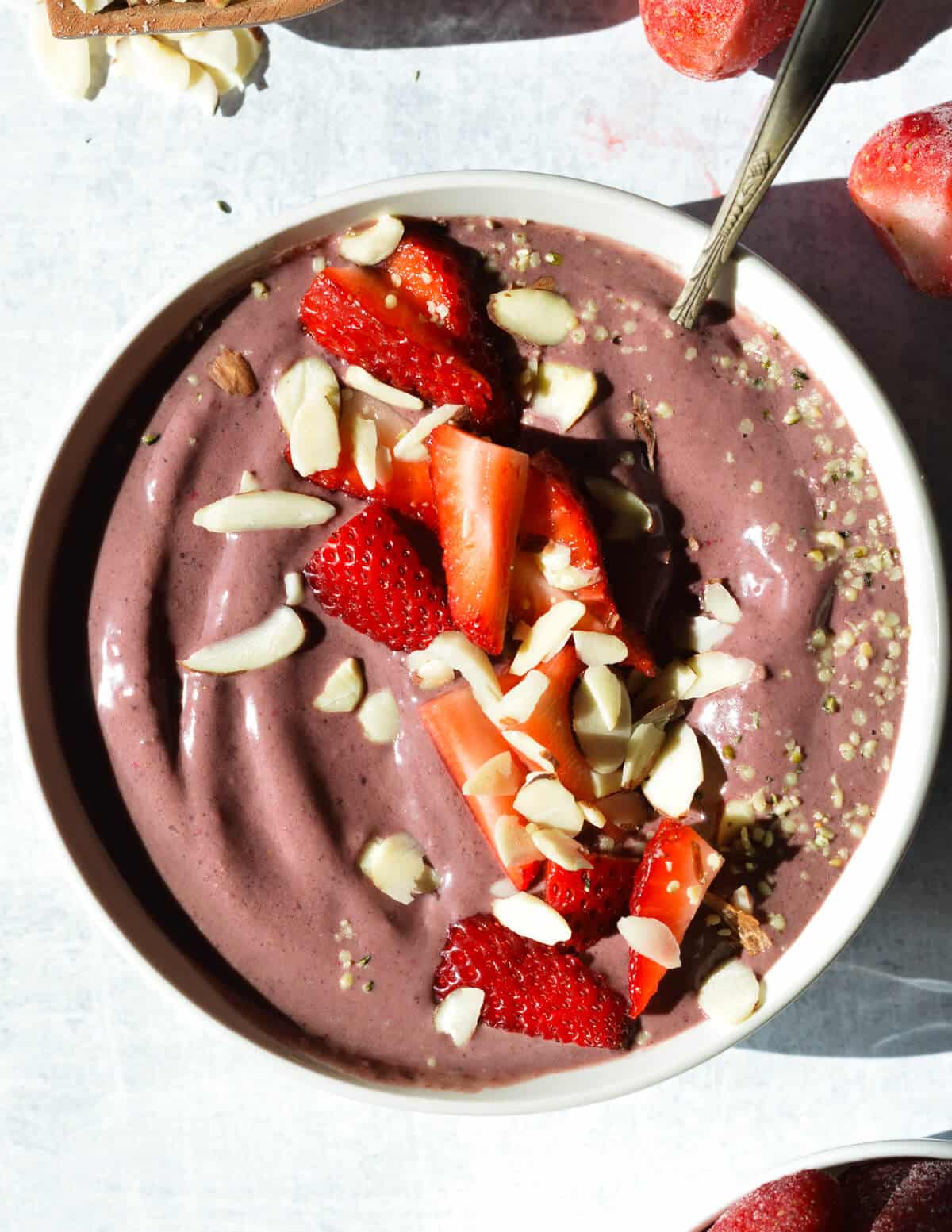 acai bowl with strawberries and almonds on top. 