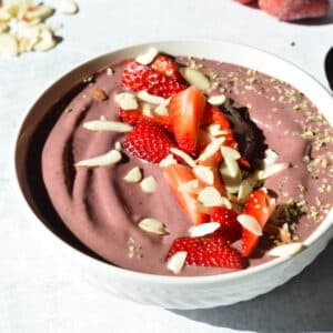 acai bowl with strawberries and almonds on top.